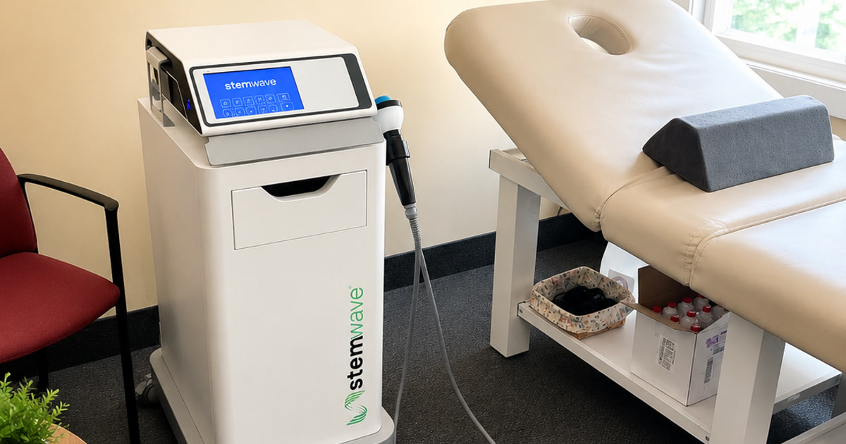 StemWave acoustic wave therapy unit and handpiece beside a treatment table at Total Wellness Chiropractic in Bowie, MD