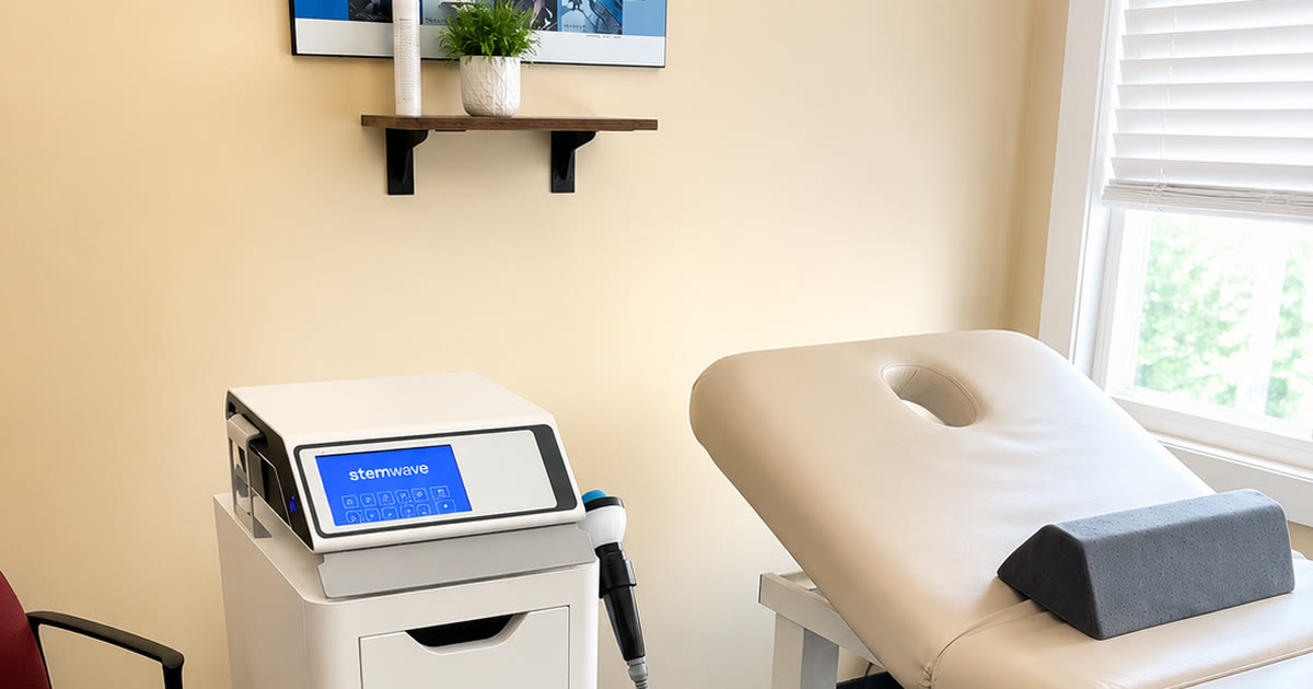 StemWave acoustic wave therapy unit and treatment table in a therapy room at Total Wellness Chiropractic in Bowie, MD